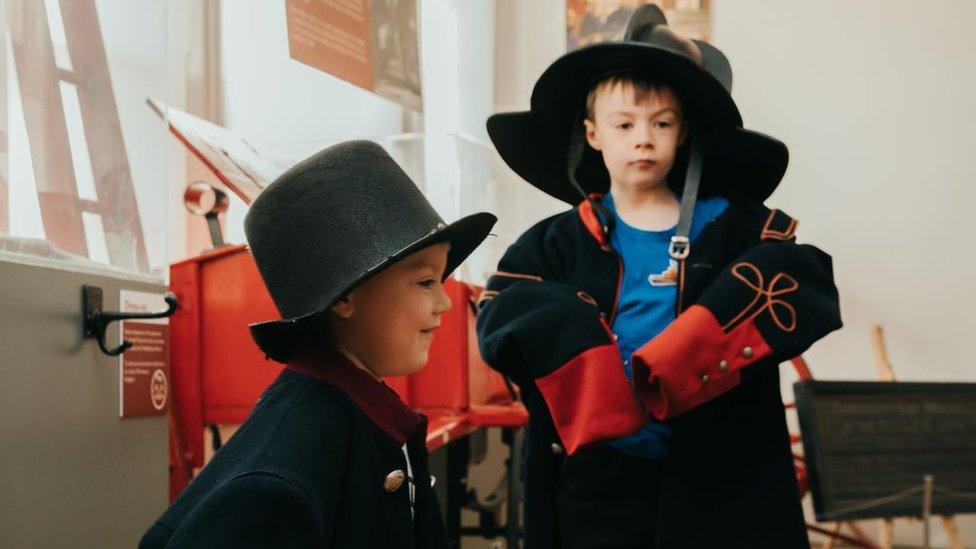 Children at the museum dressing up in historical uniforms