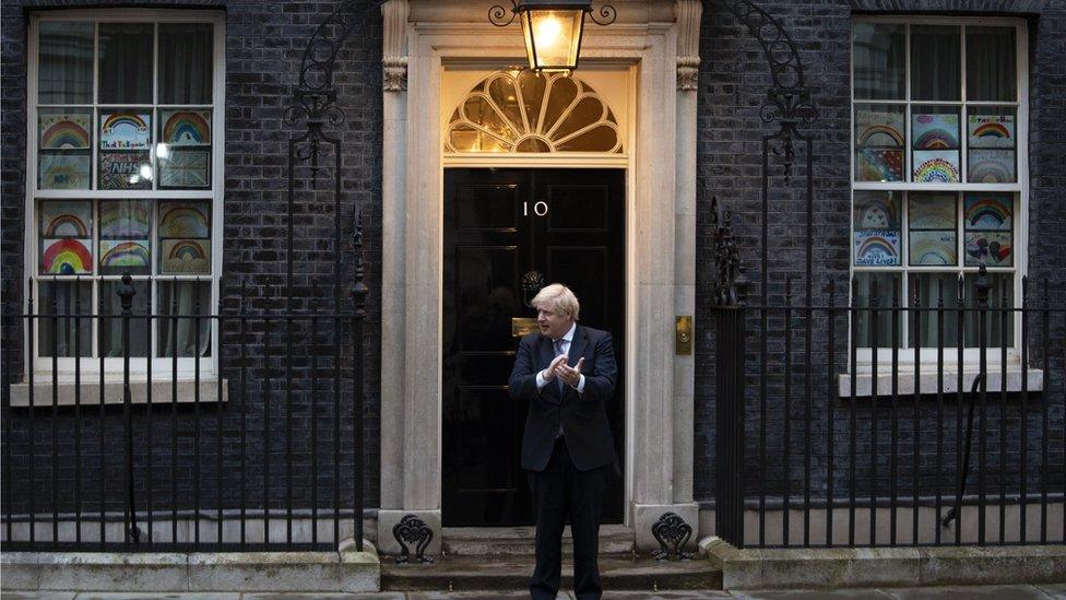 British Prime Minister Boris Johnson takes part during the "Clap for our Carers" campaign in support of Britain"s National Health Service (NHS) in front of 10 Downing Street in central London