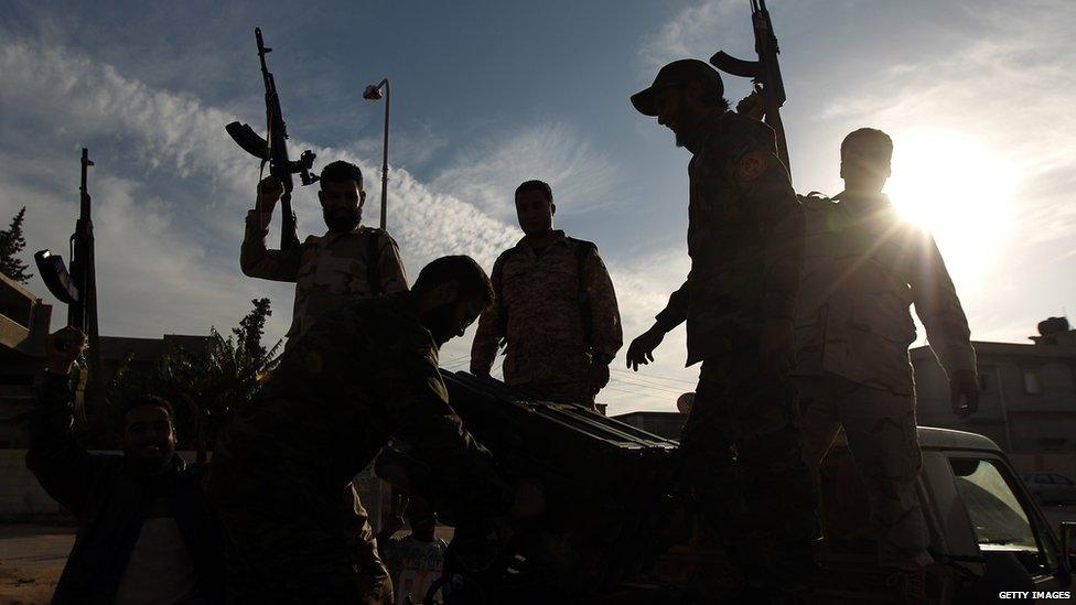 Members of a brigade headed by field commander Salah Bogheib and loyal to Khalifa Haftar hold up their guns as they fight alongside Libyan army troops against Islamist gunmen in the eastern Libyan city of Benghazi on December 17, 2014.