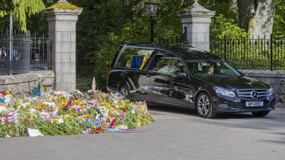 The Queen's coffin leaving Balmoral Castle in a hearse.