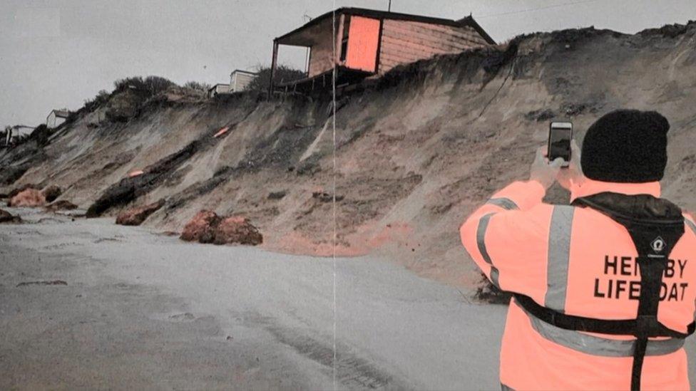 A lifeboat volunteer takes a picture of the couple's home hanging over the cliff edge