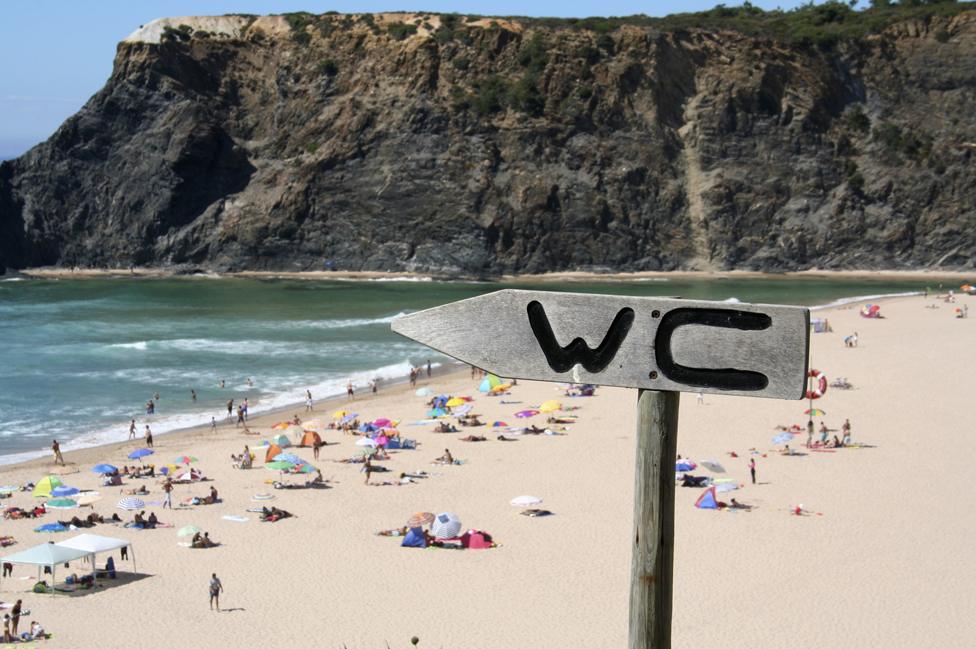 WC sign pointing to the sea