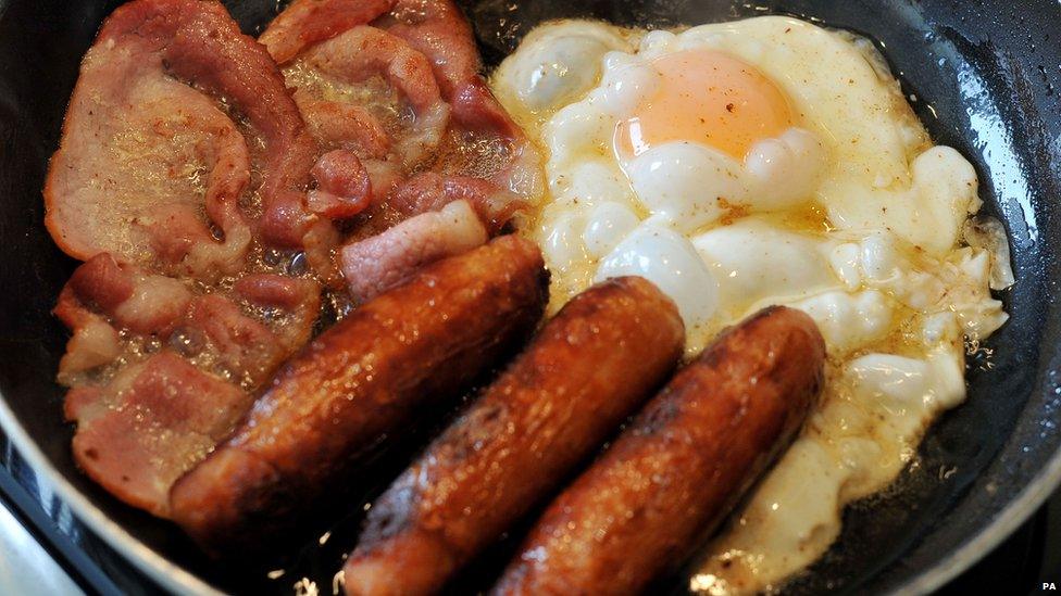 A fried breakfast of sausages and bacon