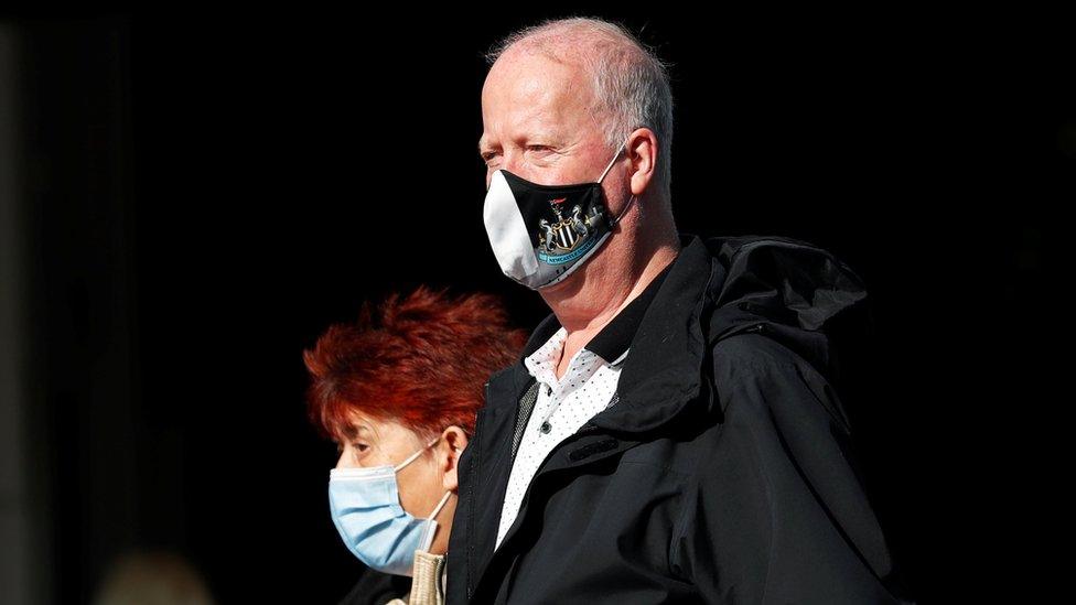 Man wearing a Newcastle United face mask