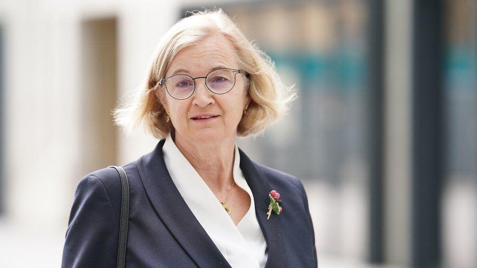 woman in blue blazer with short, light hair