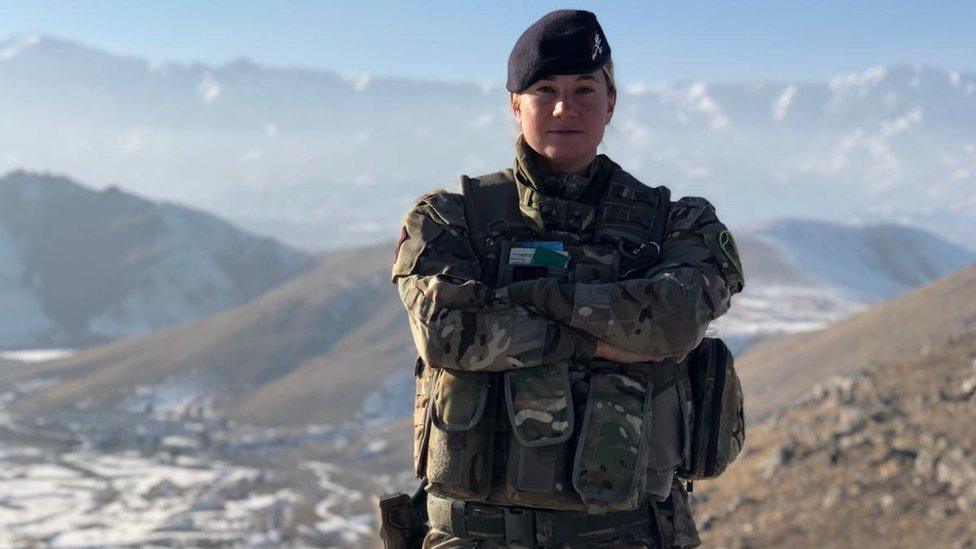 Yvette Kemp standing on a mountain in her military uniform