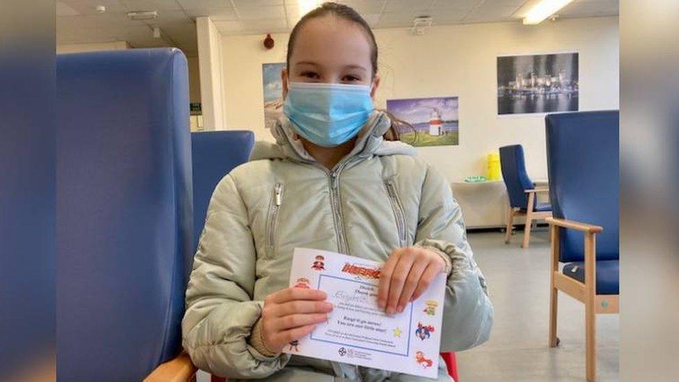 10 year old Elizabeth with her certificate after having her covid vaccination at sector house vaccination centre in Llandudno