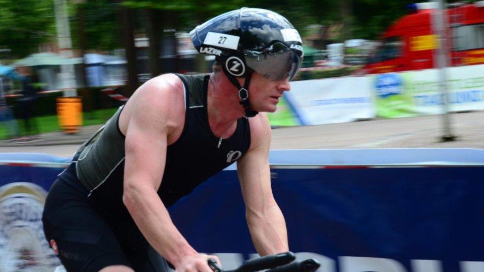 A man on a bike wearing a black helmet