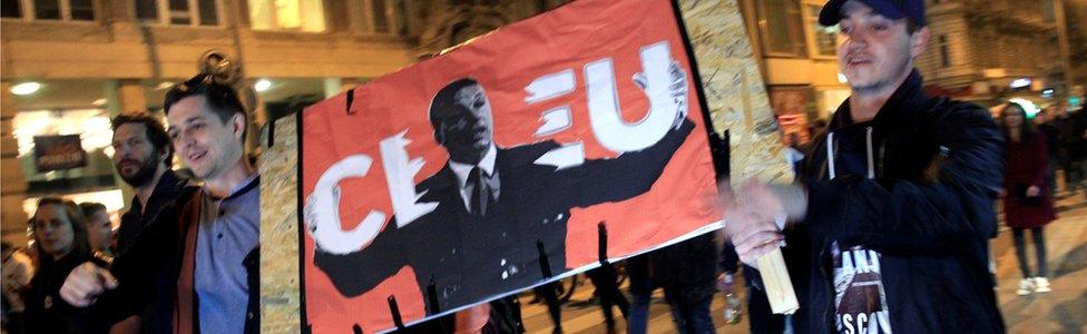 People hold a placard as they march during a protest against a new law that would undermine Central European University in Budapest on 12 April