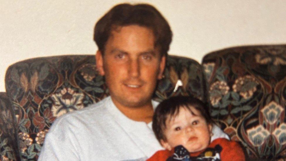 An old photograph of Gavin sitting on a sofa