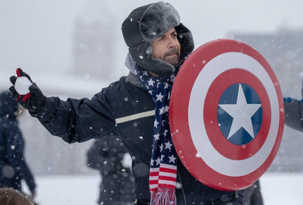 People participate in a snowball fight on the National Mall