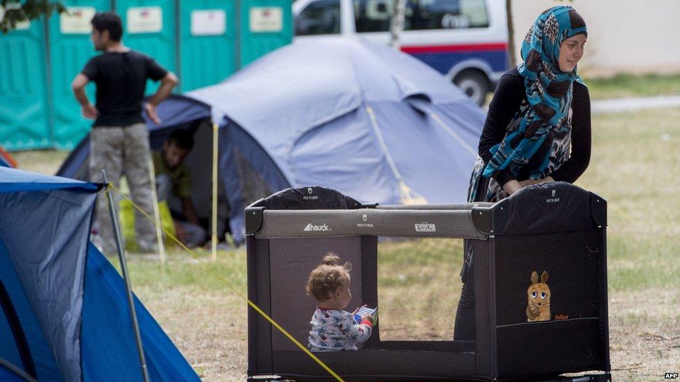 A refugee mother guards her baby in the grounds of the Traiskirchen camp