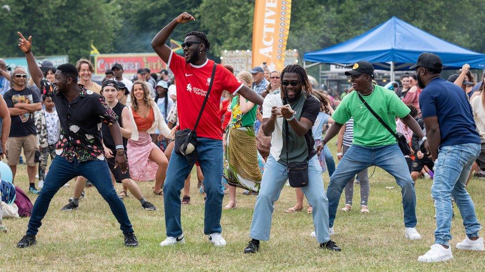 a group of men lead a crowd in a dance workshop