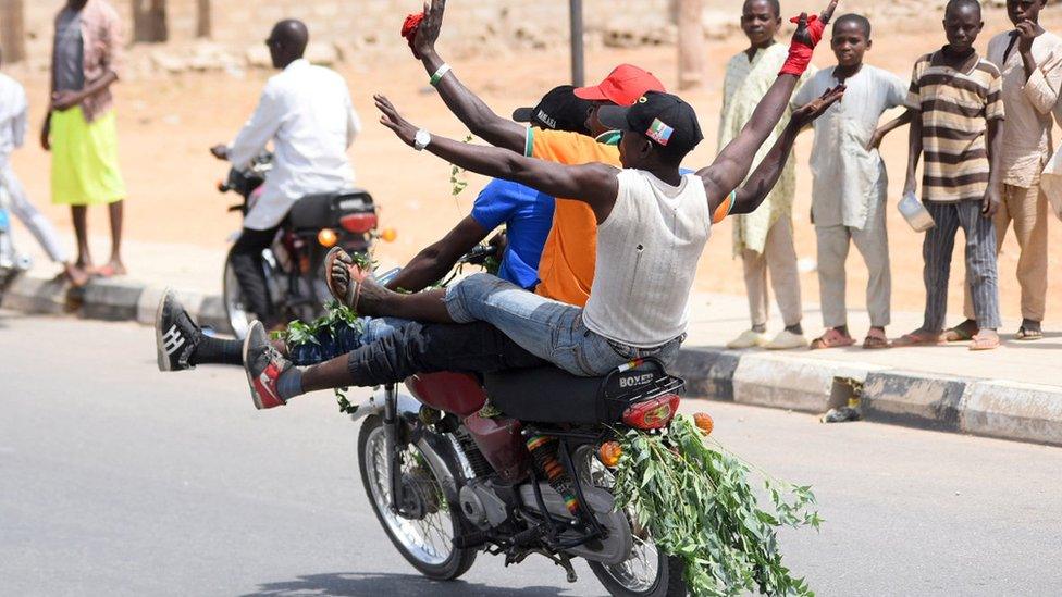 Supporters of Nigeria's President Muhammadu Buhari gesture on a motorbike as they celebrate in Katsina, Nigeria - 27 February 2019