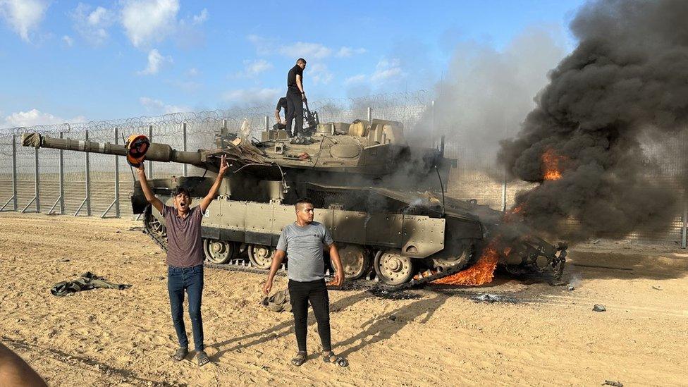 Smoke rises after Palestinian members of the Ezz Al-Din Al Qassam Brigades, the military wing of Hamas burn military armoured vehicle belonging to Israeli forces near Gaza Strip, Gaza on October 07, 2023