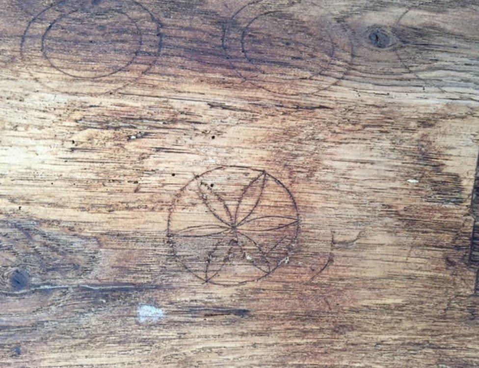 A "Daisy wheel" carved into a wooden beam, along with two more circles