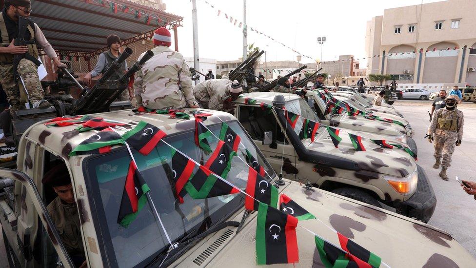 Members of an alliance of Islamist-backed fighters stand on pick up trucks in the city of Sabratha, west of Tripoli, Libya, on 28 February 2016