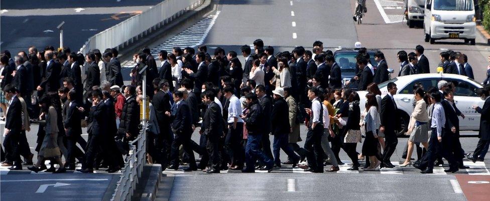 White-collar workers cross the road in Tokyo, Japan, on April 3, 2017.