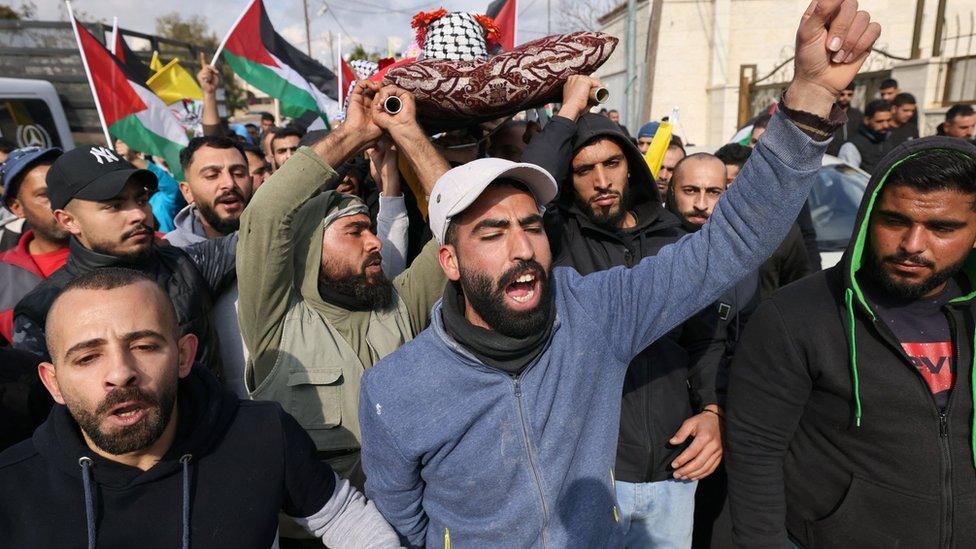 Palestinian mourners carry the body of Ahmad Kahla during his funeral in the village of Rammun, in the occupied West Bank, on 15 January 2023