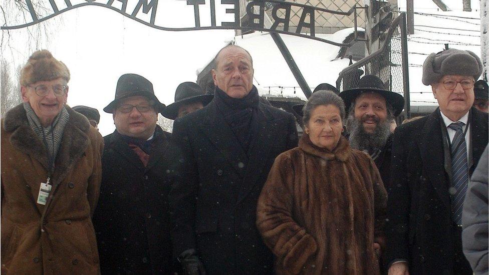 French President Jacques Chirac (3-L), Simone Veil (3-R) and Wladyslaw Bartoszewski (L), both former Auschwitz inmates, walk in front of the gate which carries the infamous "Arbeit Macht Frei" inscription, Oswiecim, 27 January 2005