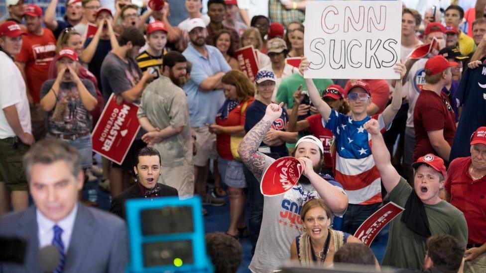 People shout behind CNN reporter Jim Acosta before a campaign rally for South Carolina Governor Henry McMaster featuring President Donald Trump at Airport High School June 25, 2018