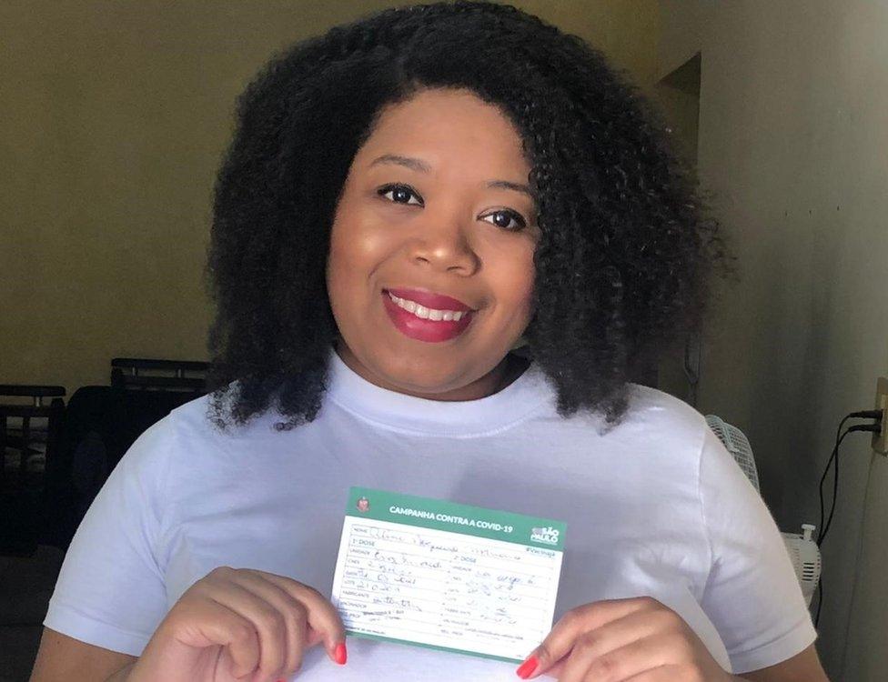 Aline Nogueira Mariano shows her vaccination card