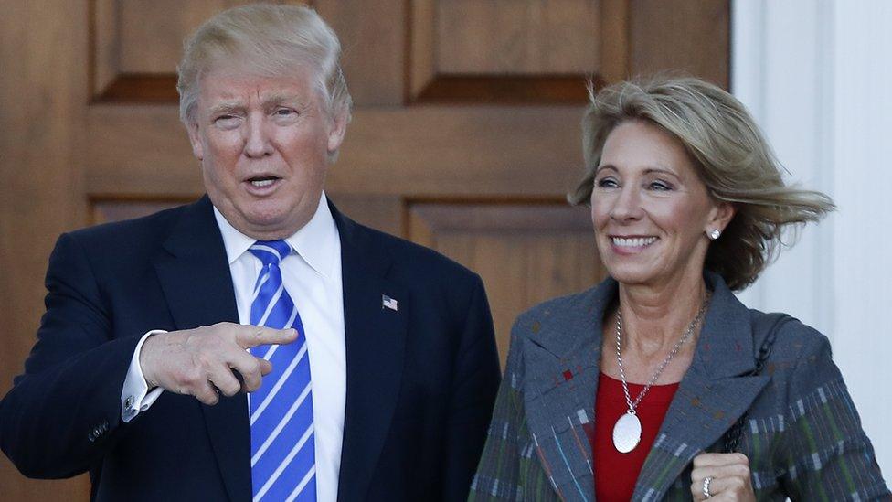 Donald Trump and Betsy DeVos pose for photos at Trump National Golf Club in Bedminster, New Jersey