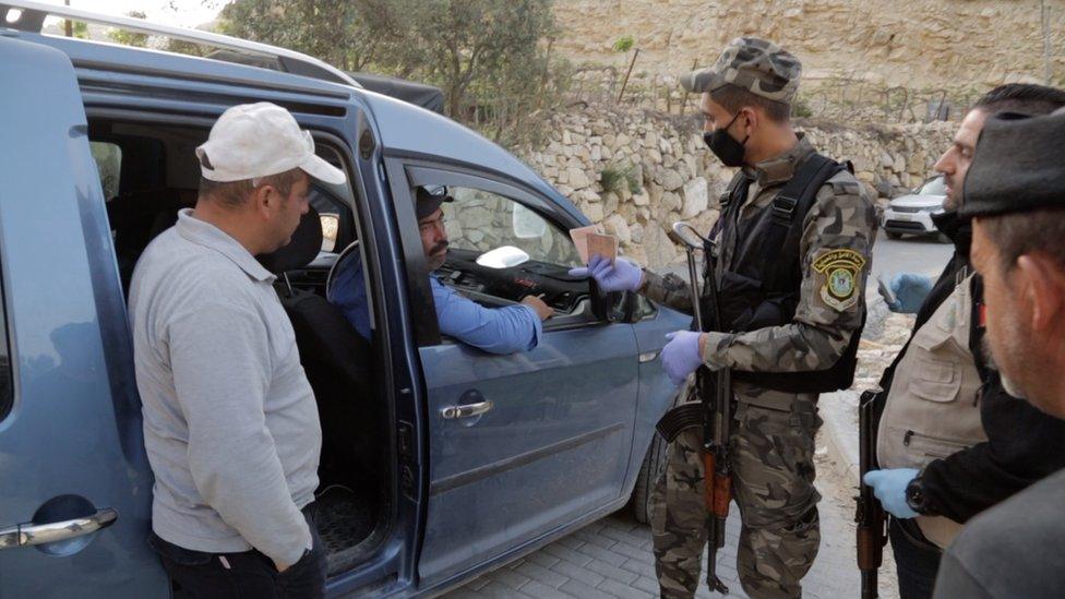 Palestinian security forces search a car near the West Bank town of Hebron to prevent workers crossing illegally into Israel