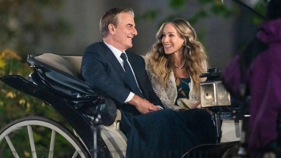 Chris Noth (L) and Sarah Jessica Parker are seen sitting in a carriage while filming And Just Like That...