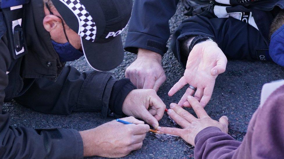 Protesters glued to the road