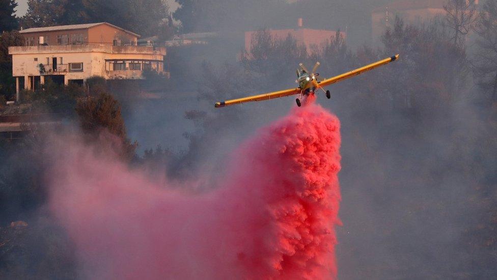 Israeli firefighting plane drops flame retardant at the village of Givat Yearim, near Jerusalem (16 August 2021)