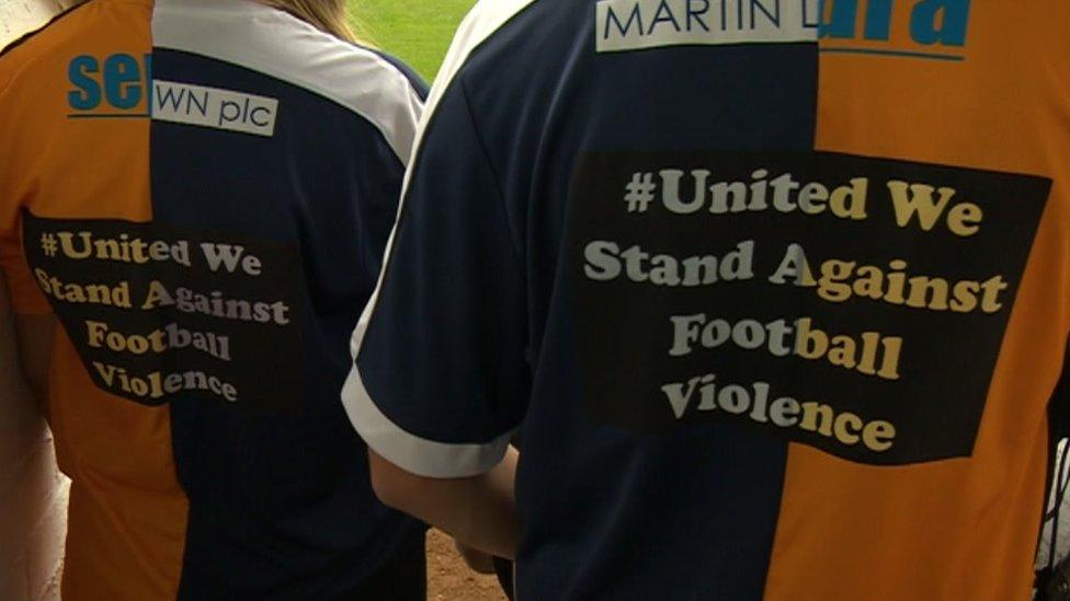 The back of a special football shirt that reads "United We Stand Against Football Violence".