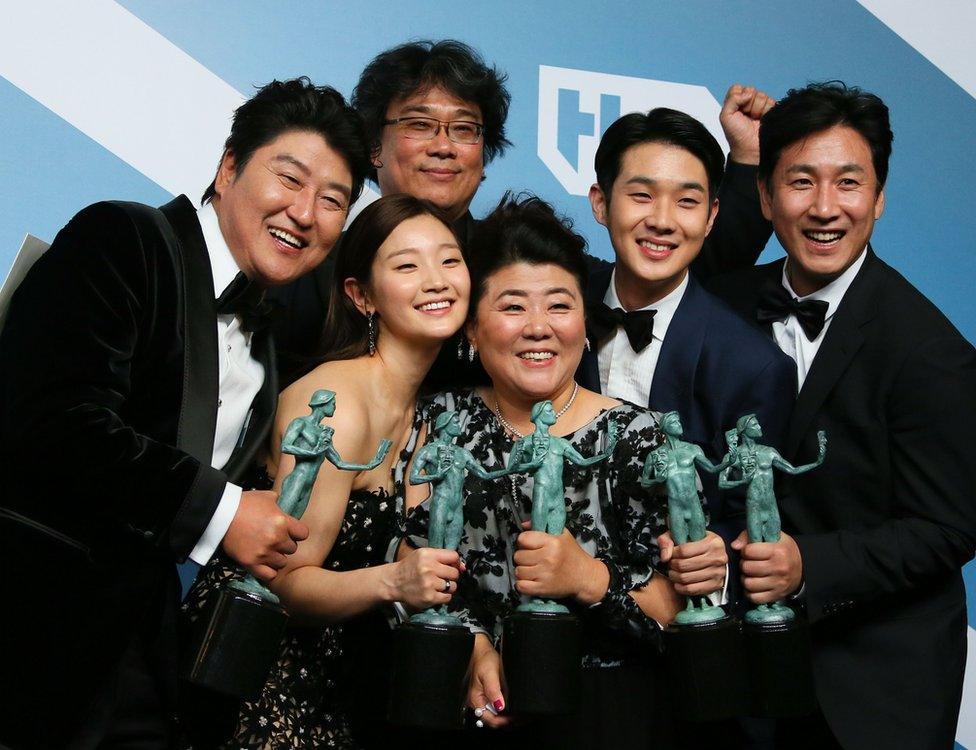 Director Bong Joon-ho stands behind the cast of Parasite