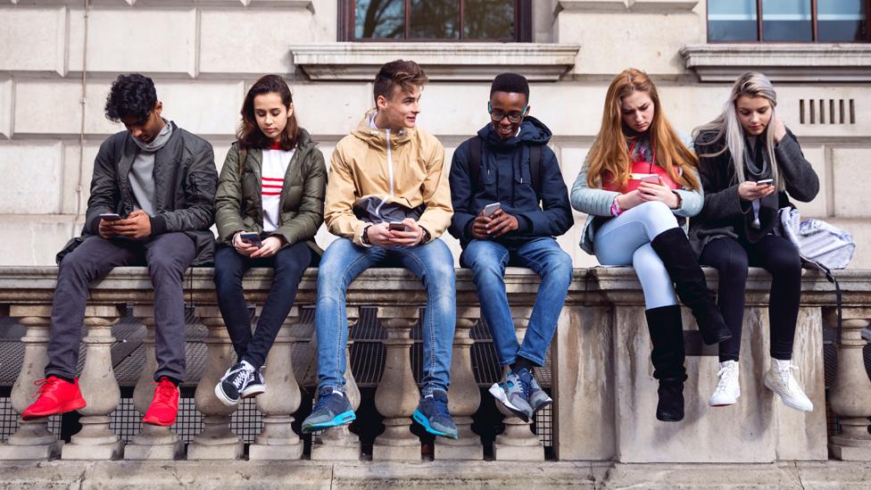 Teenagers sitting on a wall