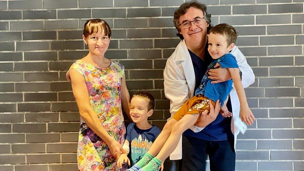 Mother-of-two Olena Sielihzjanova is pictured with her sons, five-year-old twins Nazar and Timur Sielihzjanov, and their doctor Professor Robert Rejdak who performed eye-saving surgery on all three of them