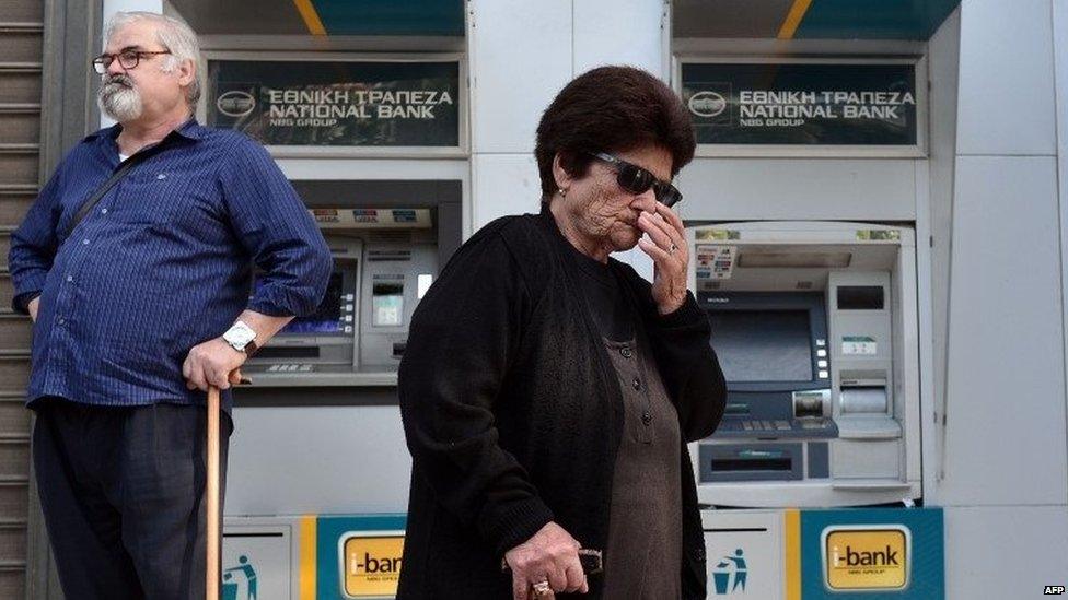 People wait by cash machines in Greece, 29 June 2015