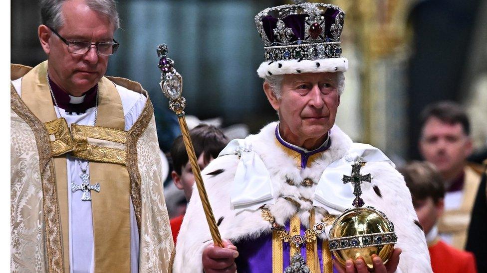 King Charles III wearing the Imperial state Crown carrying the Sovereign's Orb and Sceptre