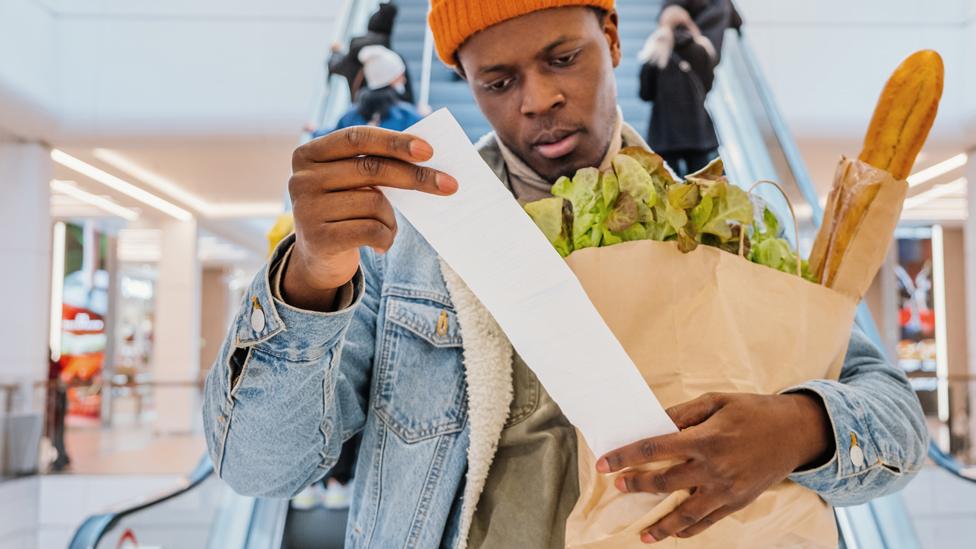 A man checking a grocery receipt