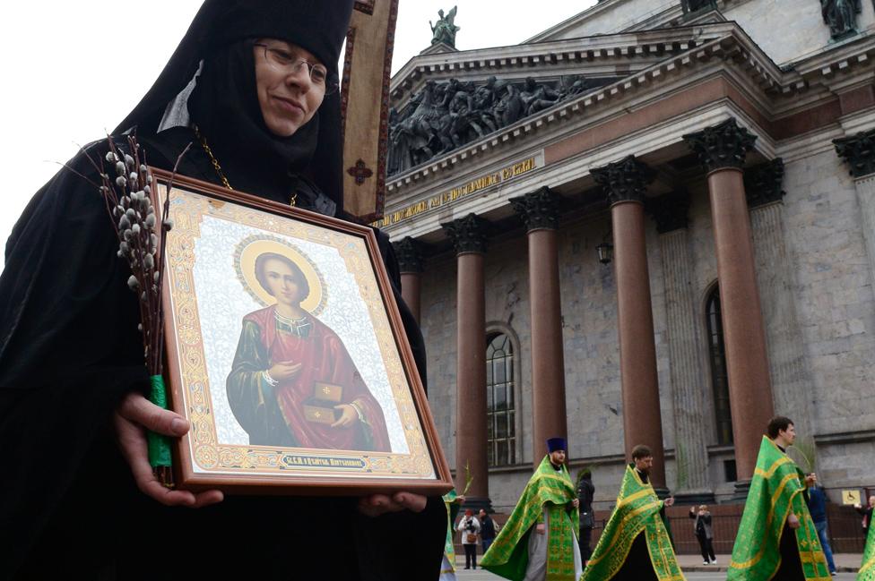 Russian Orthodox nun carries an icon outside St Isaac's Cathedral in St Petersburg, 9 Apr 17