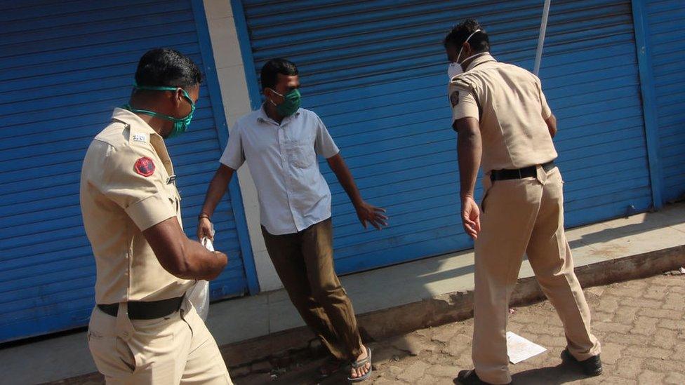 A police officer swings his baton against a man in Mumbai, India on April 11, 2020.