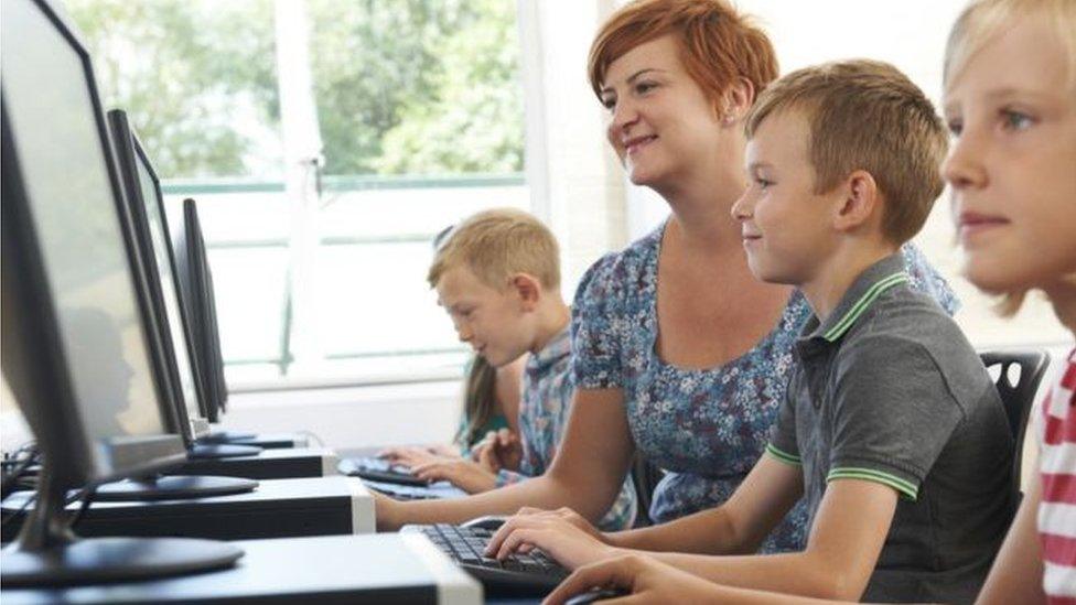 Teacher with pupils at a computer