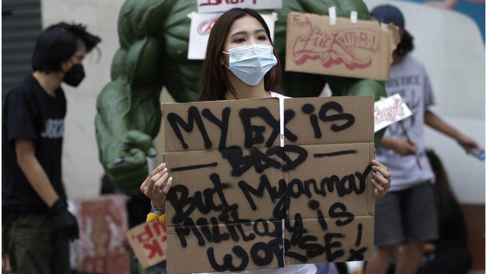 A demonstrator holds a placard reading "My Ex is Bad but Myanmar Military is Worse!" in front of a sculpture of the "Incredible Hulk" fictional character during a protest against the military coup in Yangon, Myanmar, 12 February 2021