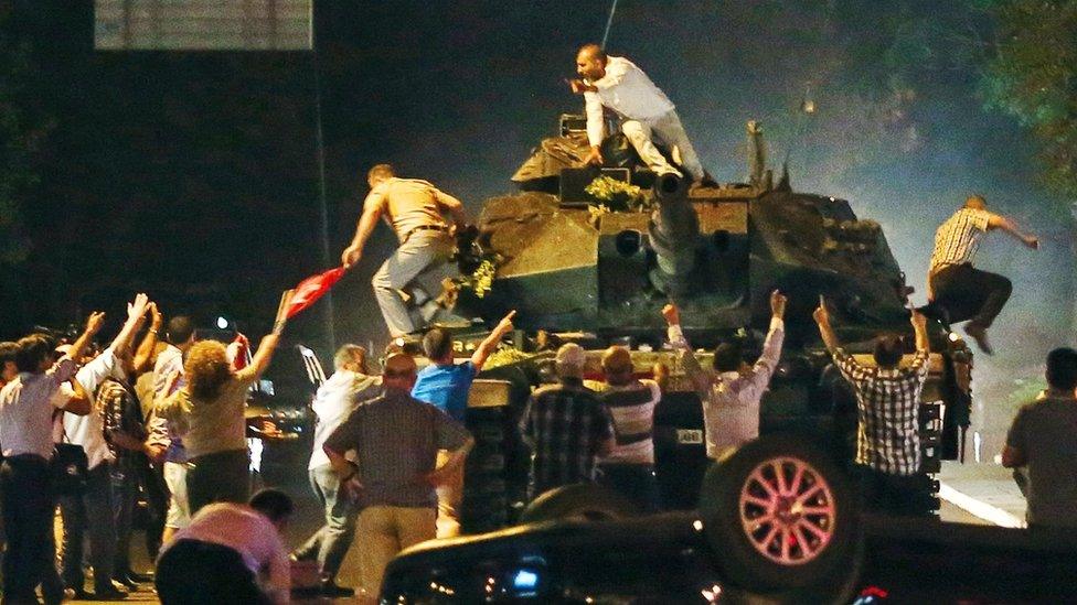 Turkish people climb on a tank attempting to stop the coup attempt in the early morning of July 16th in Ankara