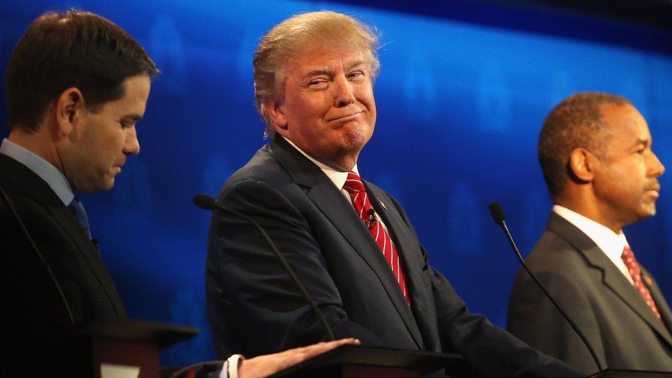 Donald Trump smirks next to Ben Carson and Marco Rubio.