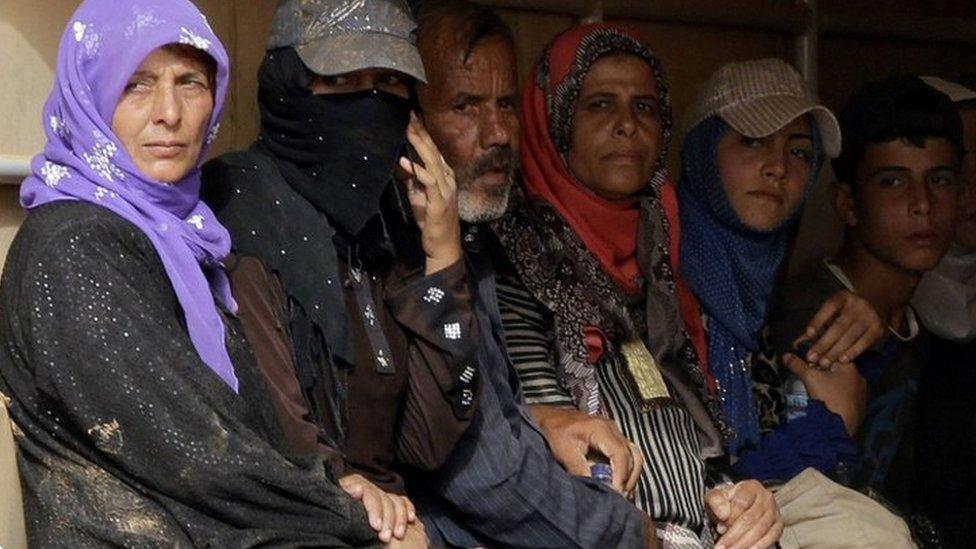 Syrian refugees sit in the back of a Jordanian army truck as they leave the al-Roqban makeshift camp, on the border with Syria