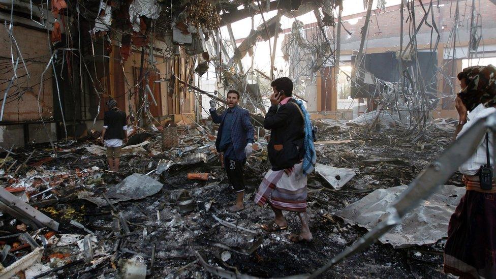 Yemeni rescue workers search for victims amid the rubble of a destroyed building following reported airstrikes by Saudi-led coalition air-planes on the capital Sanaa on October 8, 201