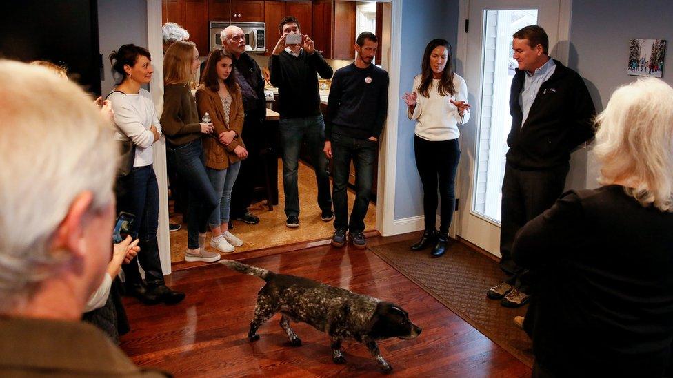 The family dog walks through the room as Democratic U.S. presidential candidate Michael Bennet