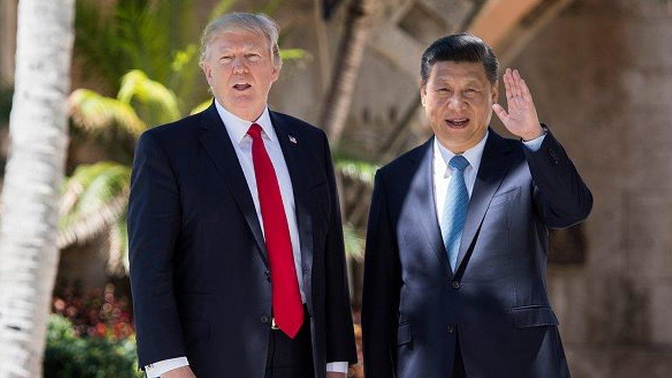 Chinese President Xi Jinping (R) waves to the press as he walks with US President Donald Trump at the Mar-a-Lago estate in West Palm Beach, Florida, April 7, 2017.