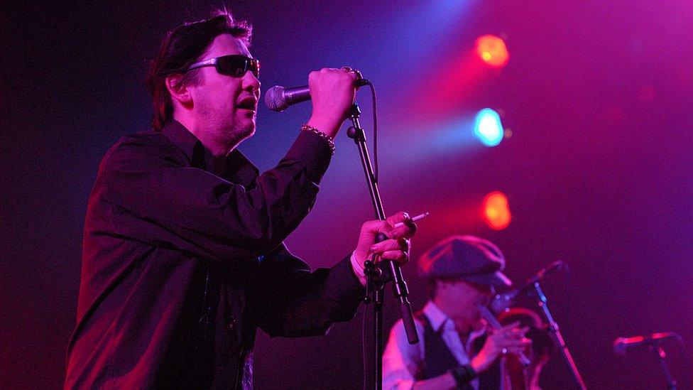 Shane MacGowan singing on stage