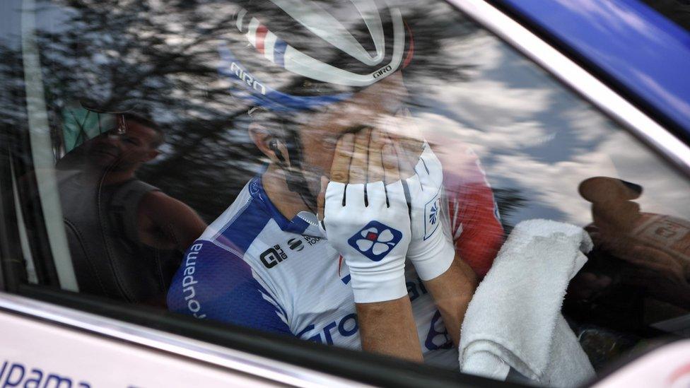 France's Thibaut Pinot, in his team car, reacts after quitting the Tour